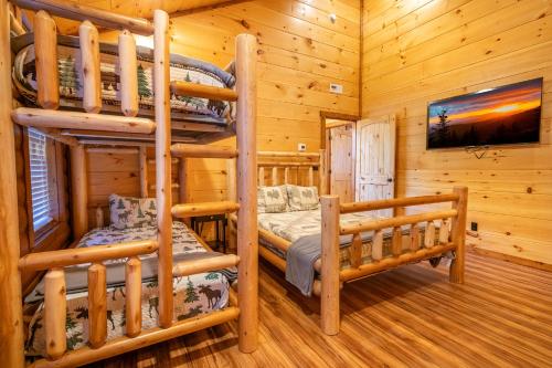 a bedroom with two bunk beds in a log cabin at Three Little Bears 2 By Avada Properties in Gatlinburg