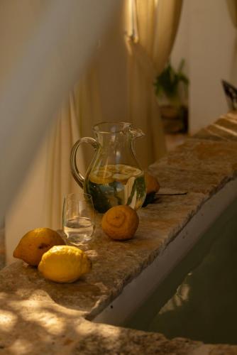 a table with a vase and some fruit on it at Masseria Tarsia Morisco in Polignano a Mare