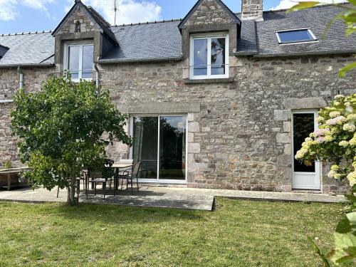 a stone house with a table and chairs in the yard at 754 - Maison 3 chambres à 800m de la plage des Montiers in Erquy