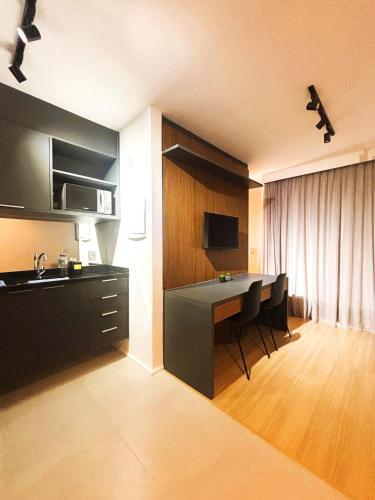a kitchen with a desk and a table with chairs at SouIcaraí by Housi in Niterói