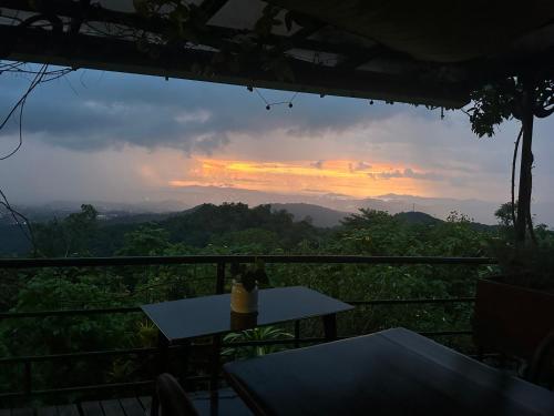 a view of a sunset from a restaurant with a table at Sinurambi Cottage Rental in Penampang