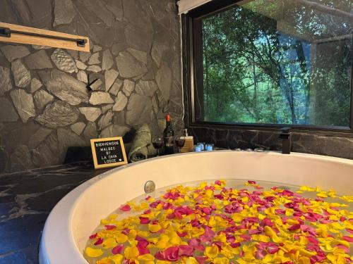 a bath tub full of flowers in a bathroom at Cabaña Malbec - La Cava Lodge in Medellín