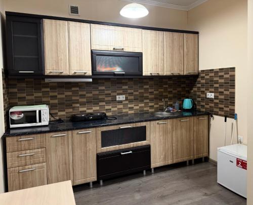a kitchen with wooden cabinets and a microwave at Modern Apartments in Mukacheve