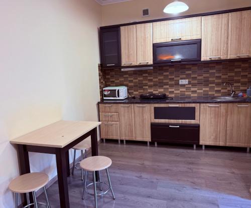 a kitchen with a table and chairs and a microwave at Modern Apartments in Mukacheve