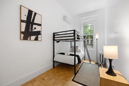 a bedroom with a bunk bed and a lamp at Vintage Luxe NY - Designer Lofts & Apartments NYC in New York