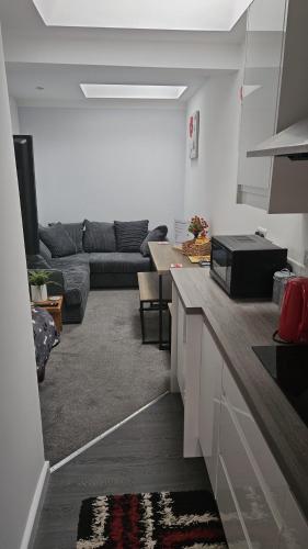 a kitchen with a living room with a couch at Cosy Corner - Town centre flat with free nearby parking in Shrewsbury