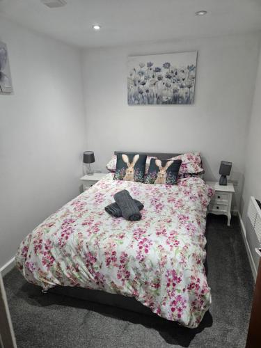 a bedroom with a bed with a floral bedspread at Cosy Corner - Town centre flat with free nearby parking in Shrewsbury