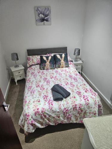 ein Schlafzimmer mit einem Bett mit geblümter Tagesdecke in der Unterkunft Cosy Corner - Town centre flat with free nearby parking in Shrewsbury