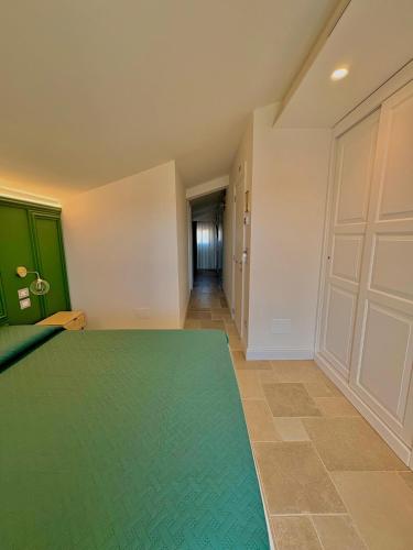 a room with a green rug and a hallway at La Posta del Guardiano in Vieste