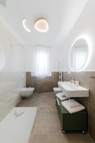 a bathroom with a sink and a tub and a toilet at Lumia Living Limone in Limone sul Garda