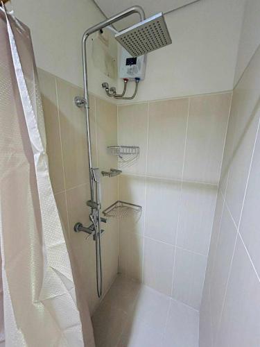 a shower with a shower head in a bathroom at Shell Residences MOA - Josh staycation in Manila