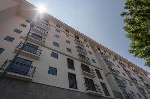 een hoog wit gebouw met ramen en de zon bij Beautiful cozy apartment in Cuzco