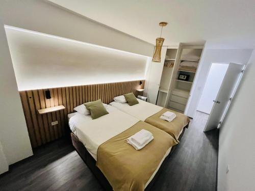 a bedroom with a large bed with two towels on it at Beautiful cozy apartment in Cusco