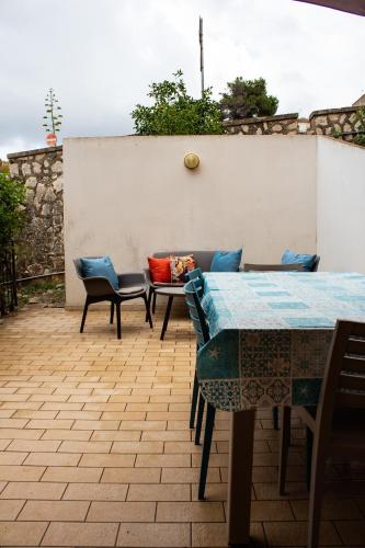 un patio con tavolo, sedie e parete di Custonaci Addisio Home a Custonaci