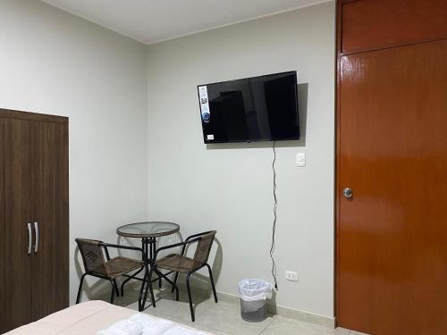 a room with a table and a tv on the wall at Mablia Suite in Ica