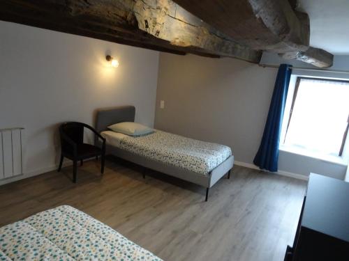 Zimmer mit 2 Betten, einem Stuhl und einem Fenster in der Unterkunft Gîte Aronde in Roz-sur-Couesnon
