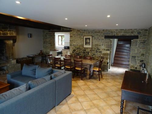 ein Wohnzimmer mit einer Couch und einem Tisch und Stühlen in der Unterkunft Gîte Aronde in Roz-sur-Couesnon