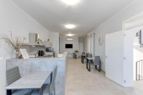 a kitchen and dining room with a counter and chairs at Villa dei due mari in Morciano di Leuca