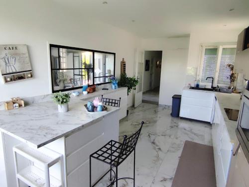 a kitchen with a counter and chairs in a room at Proche Paris, Aéroports Roissy Charles de Gaulle, Bourget, Parc des Expositions Villepinte in Arnouville-lès-Gonesse