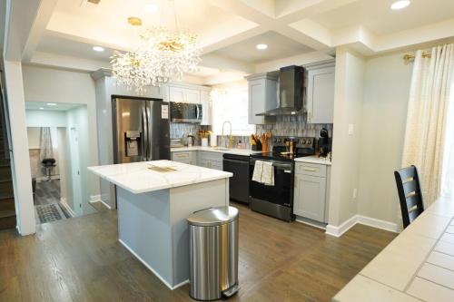 una cucina con armadi bianchi e piano di lavoro bianco di Modern Luxe Retreat -Heart of Chesterfield a Richmond