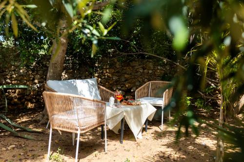 two wicker chairs and a table with food on it at Villa Cannamele in Carini