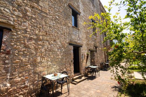 a stone building with tables and chairs in front of it at Villa Cannamele in Carini