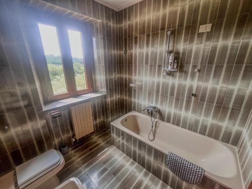 a bathroom with a tub and a toilet at Podere YogAyur in Parrano