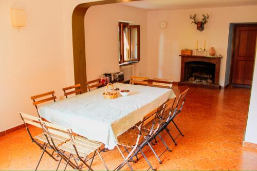 a dining room with a table with chairs and a fireplace at Podere YogAyur in Parrano