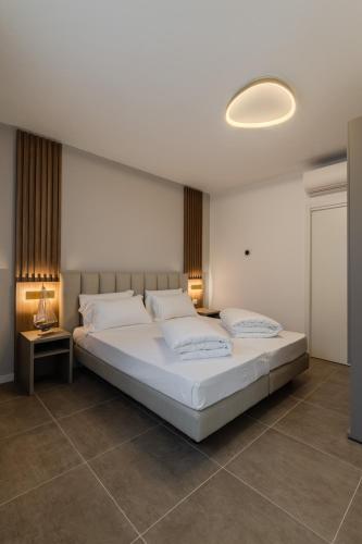a bedroom with a large bed with white sheets and pillows at Lumia Living Limone in Limone sul Garda