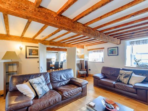 a living room with a brown leather couch at 3 Bed in Bedale 81375 in Hackforth