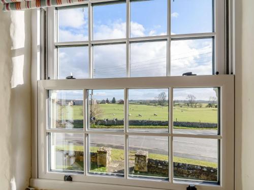 a window with a view of a green field at 3 Bed in Bedale 81375 in Hackforth