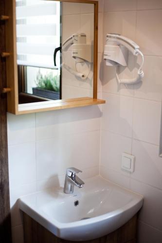 a white sink in a bathroom with a mirror at Domek na Zielonym Wzgórzu in Wisła