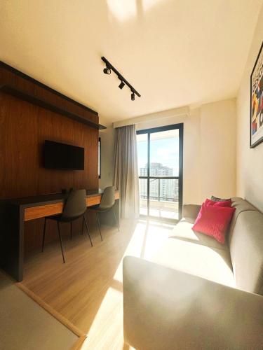 a living room with a bed and a desk and a desk at SouIcaraí by Housi in Niterói
