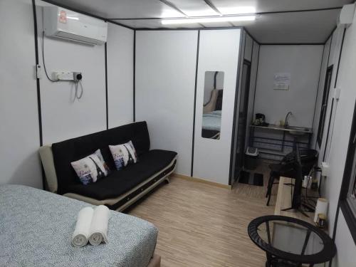 a living room with a couch and a bedroom at Haimara stayction, cabin with pool Hulu langat in Hulu Langat