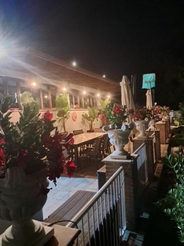 a row of tables and potted plants on a deck at night at Villa Giselda con idromassaggio in Formia