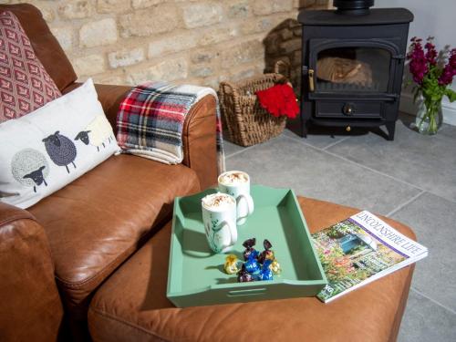 a coffee table with a tray on a couch with a book at 1 Bed in Kirkby Green 94133 in Scopwick