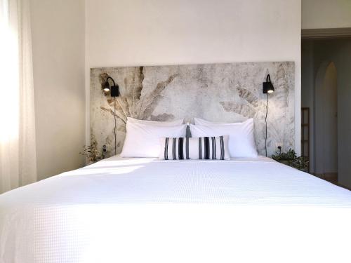a bedroom with a large white bed with two pillows at Selo Apartments Mani in Agios Nikolaos