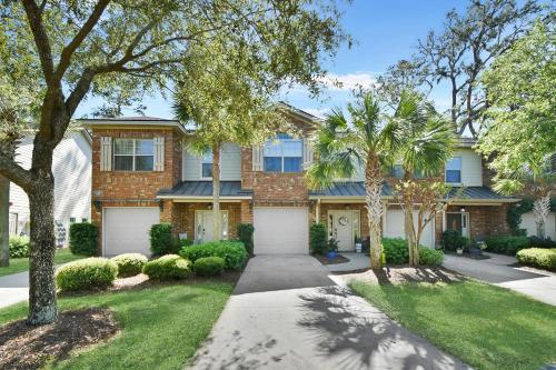 a brick house with trees and a driveway at Coastal Escape in Jewtown
