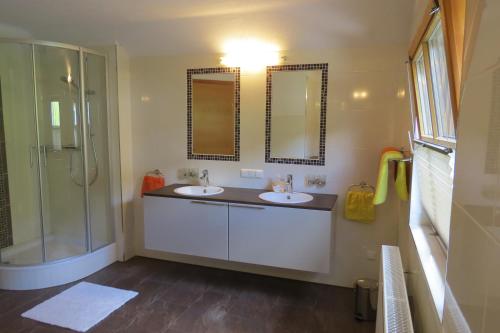 a bathroom with two sinks and a shower and mirrors at Ferienhaus Anke - Ausseerland Salzkammergut in Pichl bei Aussee