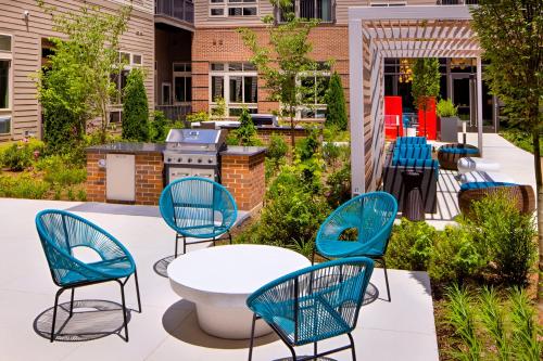a patio with chairs and a table and a grill at Modern & Bright Apartment in Alexandria in Alexandria