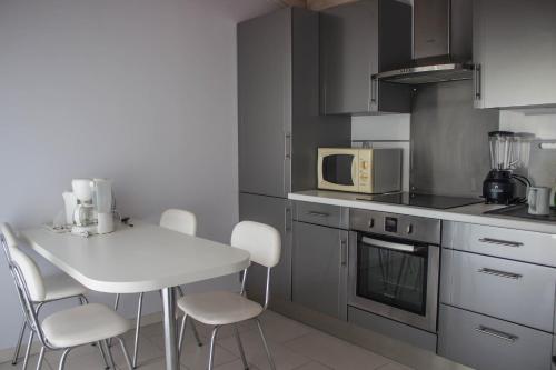 - une cuisine avec une table blanche et des chaises blanches dans l'établissement Villa Yoda, à Saint-Jean-de-Luz