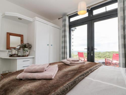 a bedroom with a large bed with pink towels on it at Sea Haven in Filey