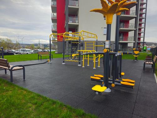 a playground with yellow equipment in a park at Green Urban Studio in Târgu-Mureş