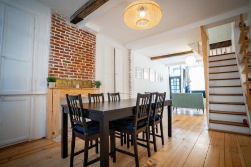 une salle à manger avec une table et des chaises noires dans l'établissement La Maison du Cœur Charme et authenticité, à Saint-Omer