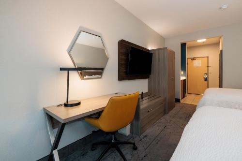 a hotel room with a desk and a bed and a mirror at Holiday Inn Express Berkeley by IHG in Berkeley