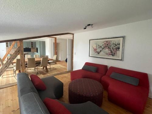 a living room with a red couch and a table at Inselperle - Kämmererhof in Fehmarn