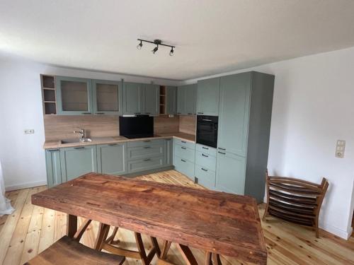 a kitchen with a wooden table and a wooden floor at Inselperle - Kämmererhof in Fehmarn
