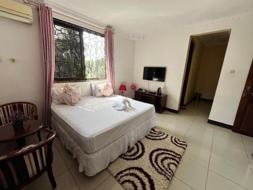 a bedroom with a bed and a window at Stay In Style Lodge in Dar es Salaam