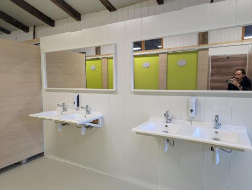 a man taking a picture of a bathroom with two sinks at Fonclaire Holidays Glamping 'Luxury Camping' in Blond