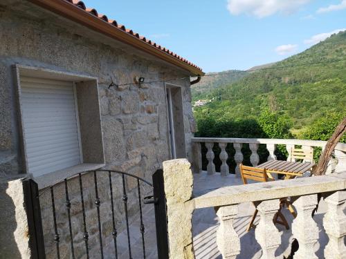 un balcone di una casa con una porta e un tavolo di Casa do Corgo a Bubaces